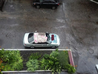 Жители Брянска оригинально спасают машину от града